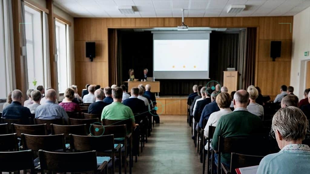 Illustration till artikeln om AI för föreningar, med årsmöte i föreningslokal och diskreta kontrollmarkörer för ansvarsfull AI-användning.