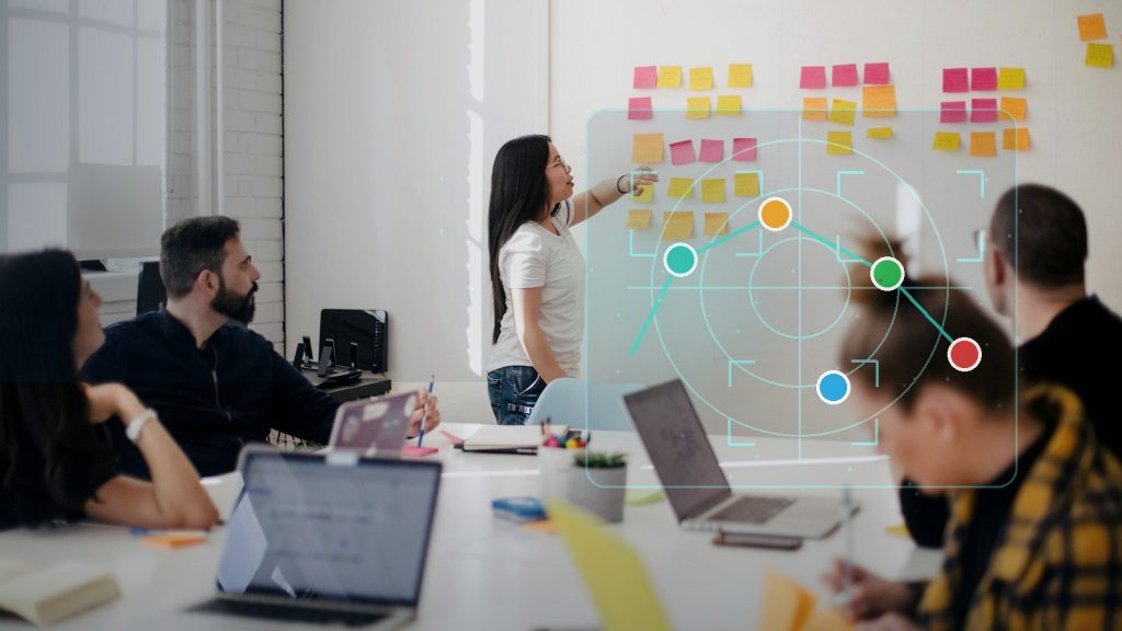Fotoillustration till artikeln om konkurrentanalys med AI, där ett team granskar konkurrenter på en workshopvägg med diskreta analysmarkörer.