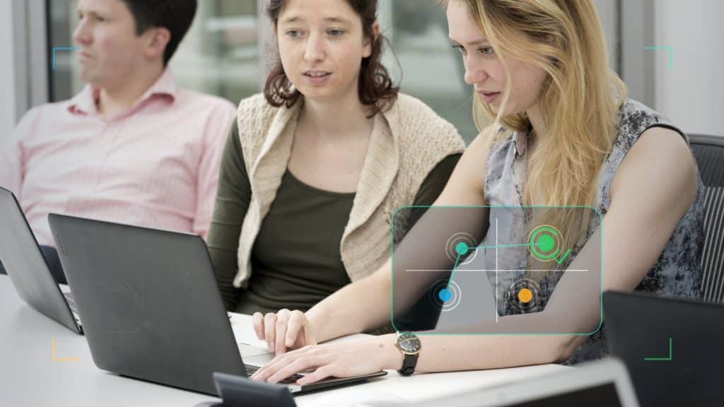 Fotoillustration till artikeln om att prioritera AI-projekt, med teamarbete vid laptop och en diskret prioriteringsmatris för effekt och risk.